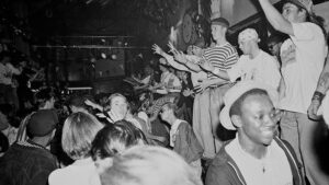 Svartvit bild av en tät publik som dansar på en klubb