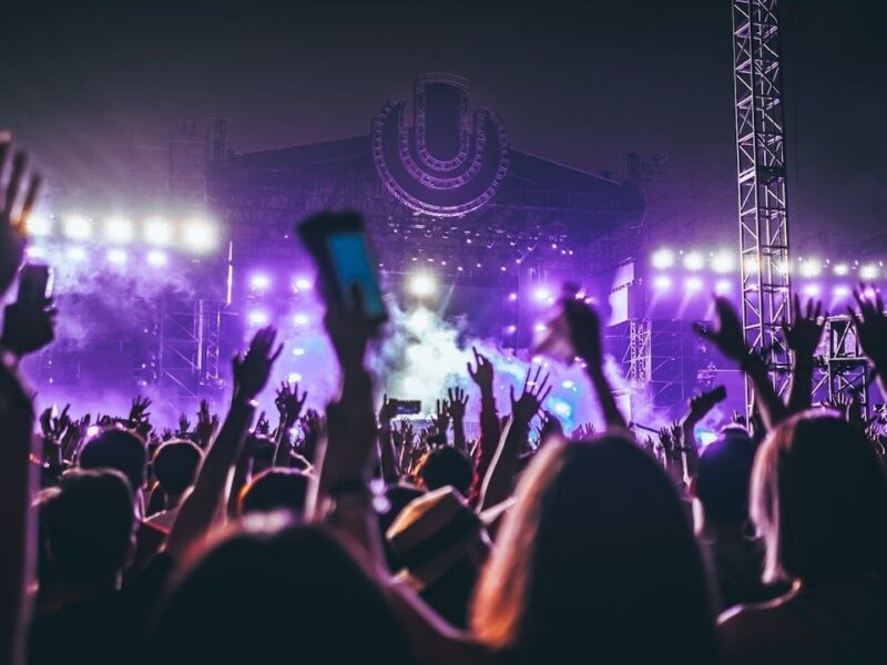 Festivalpublik framför en scen upplyst av lila strålkastare